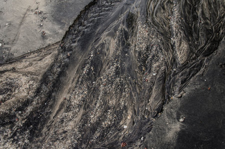Blury, Movement, Ripples in shallow water over a Black sand Beach, Langkawi, Malaysia
