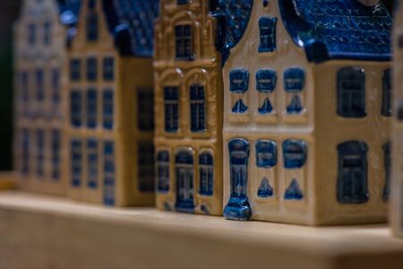 White and blue ceramic souvenir miniature of houses on wood background, Sensitive Focusの写真素材