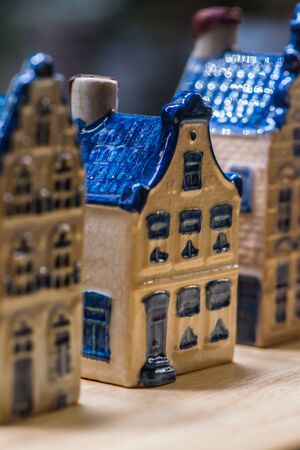 White and blue ceramic souvenir miniature of houses on wood background, Sensitive Focusの写真素材