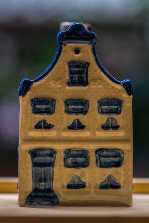 White and blue ceramic souvenir miniature of houses on wood background, Sensitive Focusの写真素材
