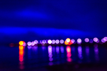 Night twilight blurred light gold bokeh reflecting on the sea surface water abstract background.の写真素材