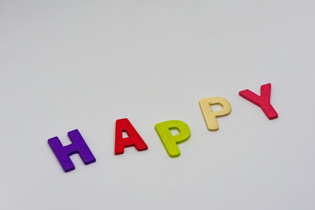 The HAPPY text from colorful wooden letters is on white backgroundの写真素材