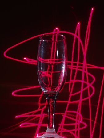 Glass of champagne on the background lights. Illumination of a night club. Still life.の写真素材