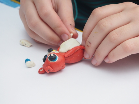 Child sculpts a figure out of plasticine. Children's artistic creativity. Close-up. Hobbies.の写真素材