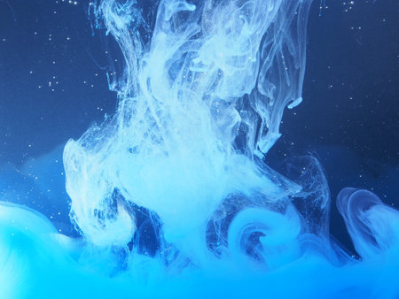 Blue paint is mixed with water. The dissolution of ink in water. Abstract photography.の写真素材