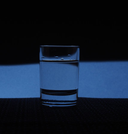 A glass of vodka is on the table. Silhouette glasses. Still-life.