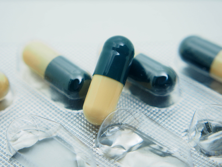 Drugs in the form of capsules. Capsules are blue and yellow. Capsules in a plastic bag. Pharmacology.の写真素材