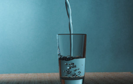 The stream of vodka is poured into a glass. Still-life.