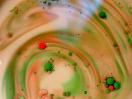 Spheres of white, pink, green, and red color on a multi-colored background. Colored drops in oil....