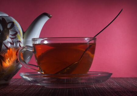 Tea with lemon in a clear glass and a porcelain teapot. Still-lifeの写真素材