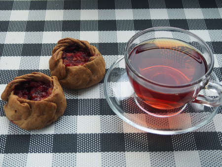 On the table are pies stuffed with fruit and berries and a Cup of tea. Still-lifeの写真素材