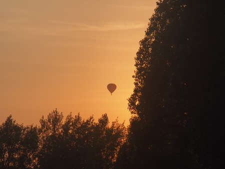 Balloons float across the sky against the background of sunset. Landscape.の写真素材