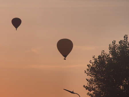 Balloons float across the sky against the background of sunset. Landscape.の写真素材