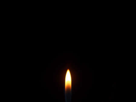 The flame of a gas lighter burns in the dark. Close-up.の写真素材
