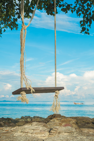wooden swing board under the tree next to the beach at Phi Phi Islandの写真素材