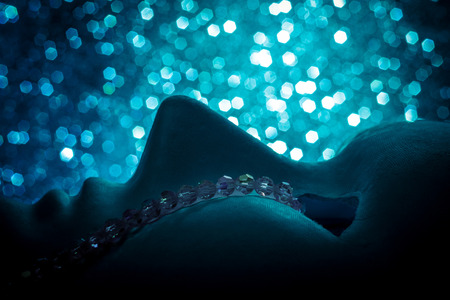 mask face up with crystal necklace as the tear. Background is brilliant bokehの写真素材