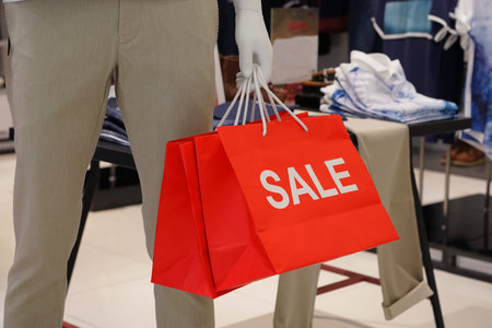 Mannequin carrying red sale paper sag in department storeの写真素材