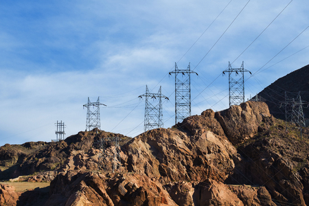 High voltage electricity poles over the mountain hills with blue sky in Hoover Damの写真素材