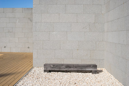 Modern minimal style exterior design gray wall stone and wooden floor and a piece of wood can be...