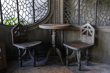 Witch or ghost looking style set of table and chairs in the corner of the room made of wood on cement floorの写真素材
