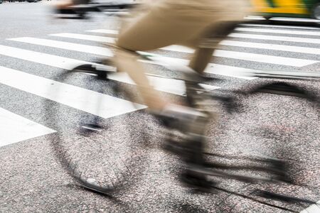 Motion blurry image man riding bicycle on the roadの写真素材
