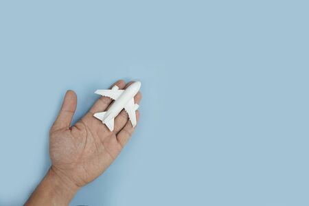 White toy plane on palm hand with blue backgroundの写真素材