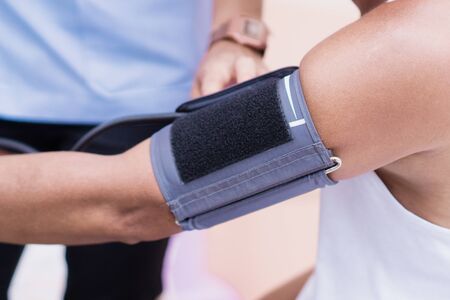 Arm of Asian man undergoing blood pressure measurementの写真素材
