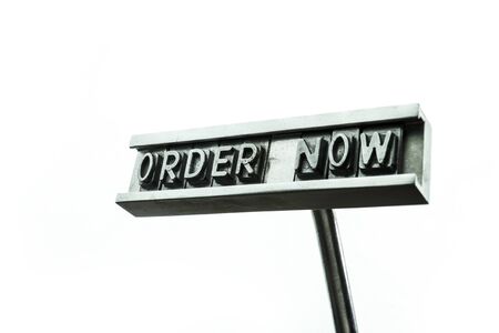 Metal stamp order now isolated on white backgroundの写真素材