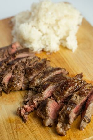 Wagyu beef steak with sticky rice on wooden cutting boardの写真素材