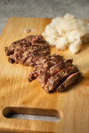 Wagyu beef steak with sticky rice on wooden cutting boardの写真素材