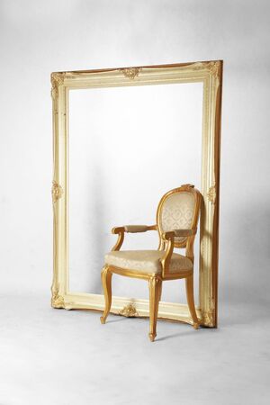 Large vintage picture frame and luxury chair in empty grungy white backgroundの写真素材