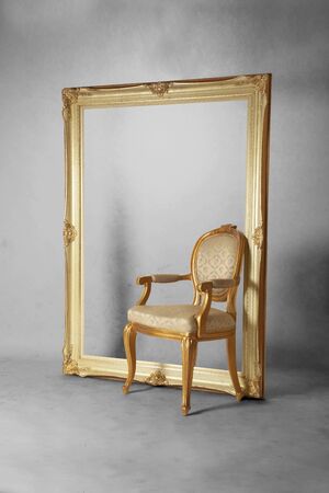 Luxurious chair and large photograph frame in dirty gray roomの写真素材