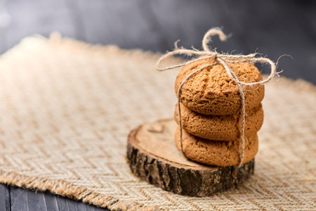 Oatmeal cookies tied with a rope on a wooden table. The concept of food for breakfast