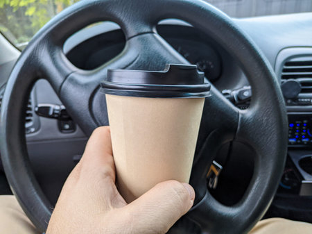 delicious aromatic coffee in the car. cup in the car. glass in hand. driver with coffee. glass with...