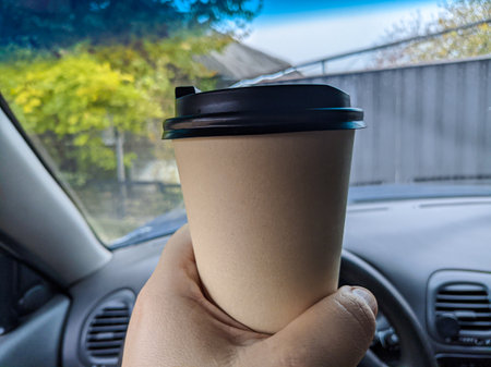 delicious aromatic coffee in the car. cup in the car. glass in hand. driver with coffee. glass with a drink on the trip. milkshake in the carの写真素材