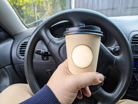 delicious aromatic coffee in the car. cup in the car. glass in hand. driver with coffee. glass with a drink on the trip. milkshake in the carの写真素材