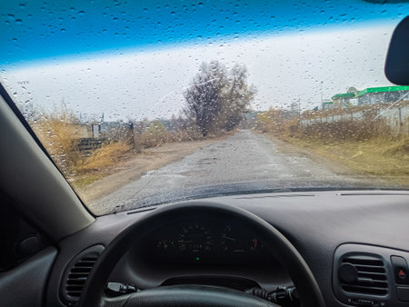 raindrops on the glass of the car. drive the car to the door. travel in bad weather. driver behind the wheel.の写真素材