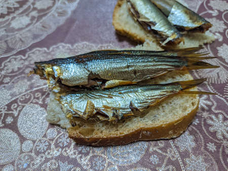 smoked fish. delicious little fish. seafood. sandwich with fish. golden fishの写真素材