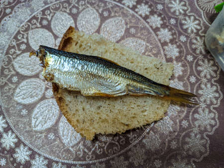 smoked fish. delicious little fish. seafood. sandwich with fish. golden fishの写真素材