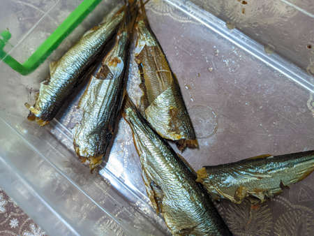 smoked fish. delicious little fish. seafood. sandwich with fish. golden fishの写真素材