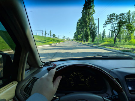 inside the car. driver behind the wheel. drive a car. journey. bad roads. by car. steering wheel and dashboard. wheels and engine.の写真素材