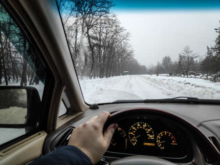 inside the car. driver behind the wheel. drive a car. journey. bad roads. by car. steering wheel and dashboard. wheels and engine.の写真素材