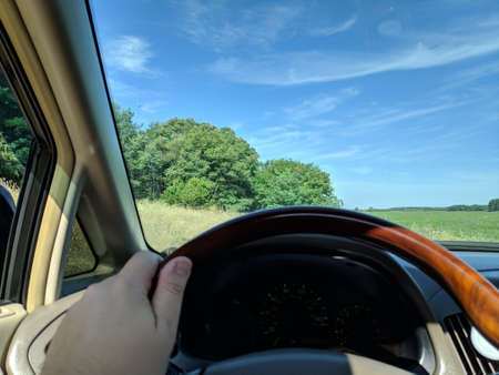 inside the car. driver behind the wheel. drive a car. journey. bad roads. by car. steering wheel and dashboard. wheels and engine.の写真素材