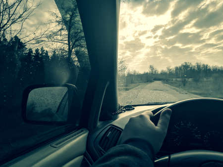 inside the car. driver behind the wheel. drive a car. journey. bad roads. by car. steering wheel and dashboard. wheels and engine.の写真素材