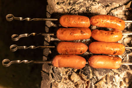 fried sausage and sausages. Grilled sausages with sauce ketchup on a wooden table.の写真素材