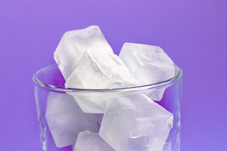 white ice cubes in a transparent glass. ice melts in a glass. transparent ice.