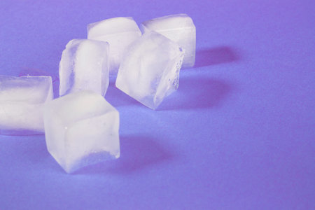 white ice cubes in a transparent glass. ice melts in a glass. transparent ice.