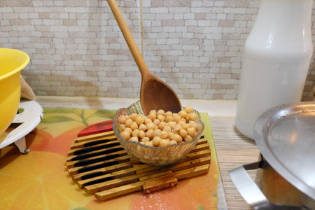 boiled chickpeas. Clay bowl with boiled chickpeas and herbs on a black wooden table. Boiled chickpeas in a clay bowl on a black wooden table. Minimalism. Vegetarian cuisine from legumes.の写真素材