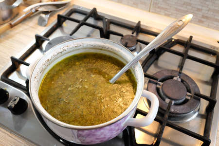 making homemade soup. delicious homemade soup. Ladle with vegetable soup. Cooking pot on background. Focus on foreground. Bowl of tasty chicken enchilada soupの写真素材