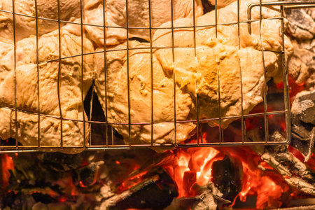 barbecue on the grill. meat on a skewer. cooking meat on fire. Skewers of meat outdoors. Man cooking marinated shashlik, lamb meat grilling on metal skewer. Flames of Fire In The Backgroundの写真素材